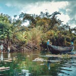 Scenic view of people boating on a lush river surrounded by vibrant greenery in Madagascar.